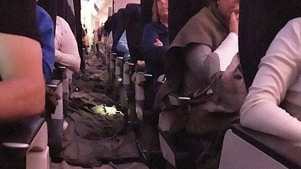 Detalle del pasillo del avión cubierto por mantas y toallas