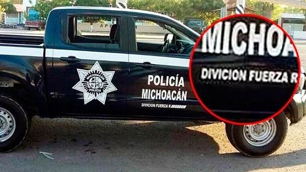 El coche de policía detenido, con el letrero que incluye la palabra «divición»