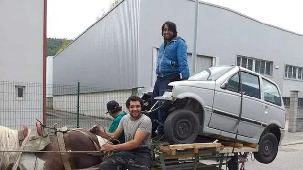 Un carro de caballos transporta un vehículo en Asturias