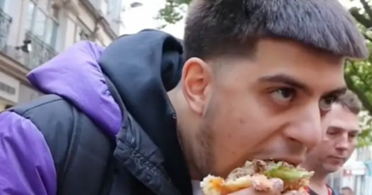 Un hombre come &#039;la hamburguesa más grande del mundo&#039; frente a una protesta vegana