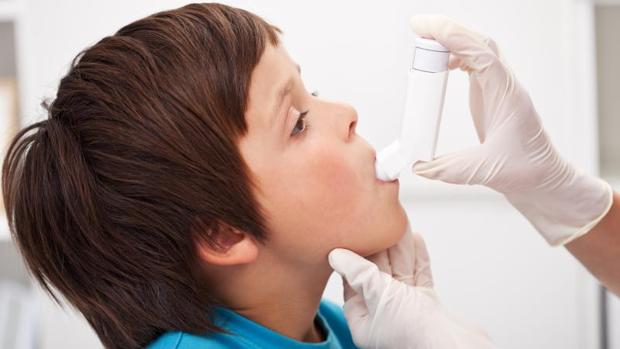 Un niño recibe tratamiento contra el asma mediante un inhalador