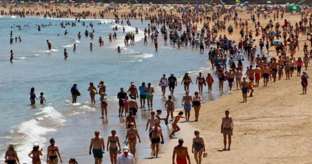 Decenas de personas disfrutan de un soleado día de verano en la playa de San Lorenzo en Gijón, Asturias, el pasado viernes