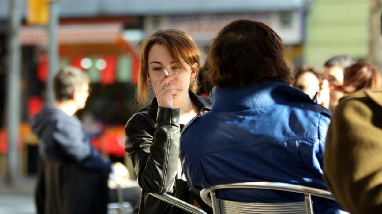 Mujet fumando en una terraza