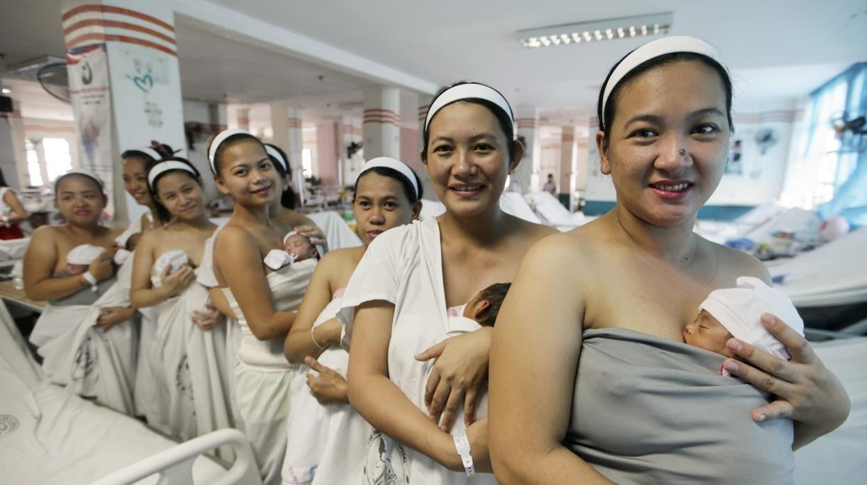 Mujeres sostienen en brazos a sus recién nacidos durante el primer contacto piel con piel, durante una campaña de la Organización Mundial de la Salud (OMS), tras dar a luz en la Maternidad Fabella en Manila (Filipinas)