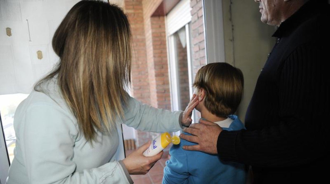 Madre protegiendo a su hijo con crema solar