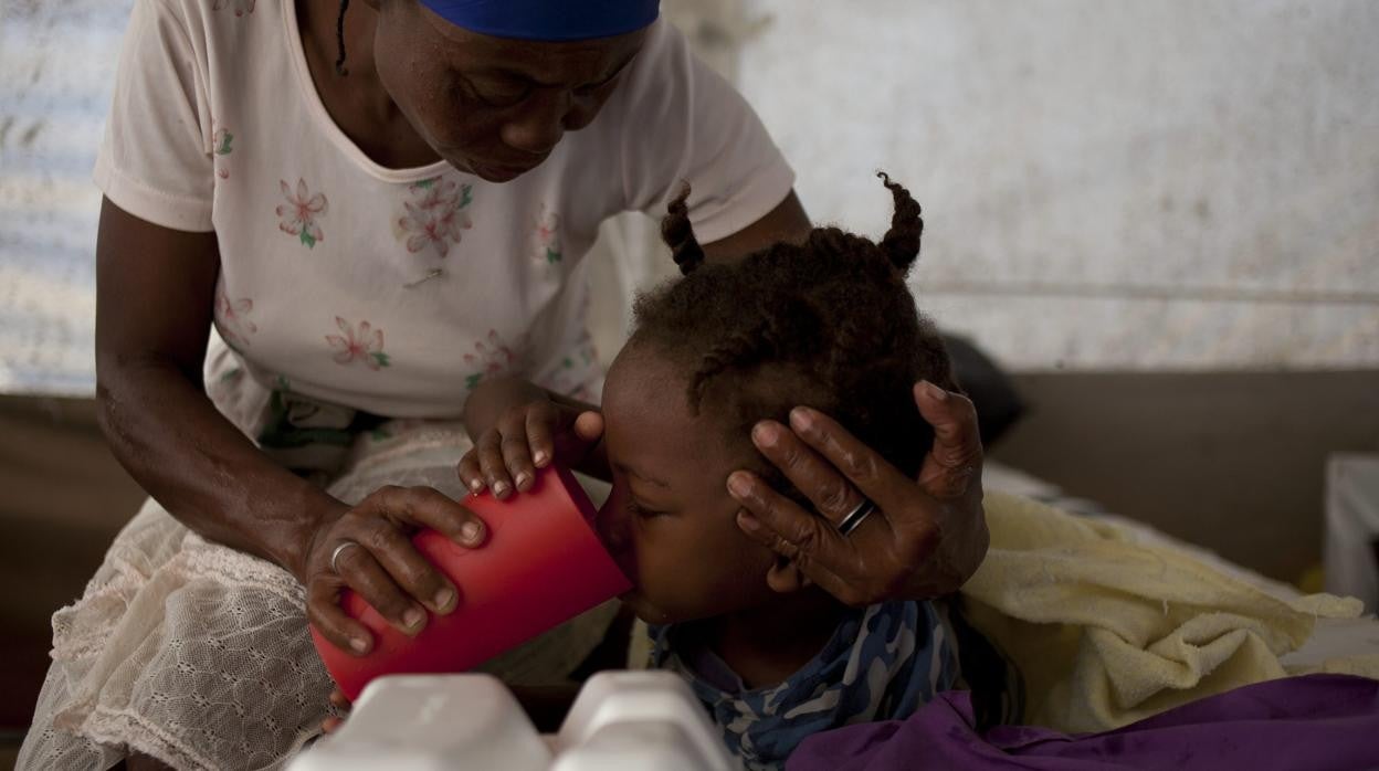 Una madre cuida a su hija, afectada por el cólera en Puerto Príncipe (Haití)