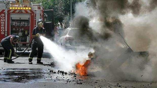 Imagen de archivo de los bomberos sofocando un fuego de contenedor