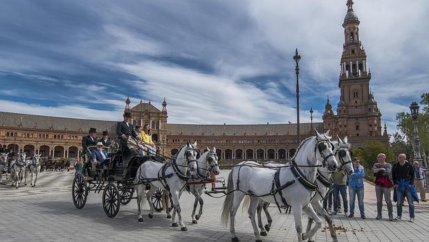 Desfile de coches de caballos por el casco historico de Sevilla