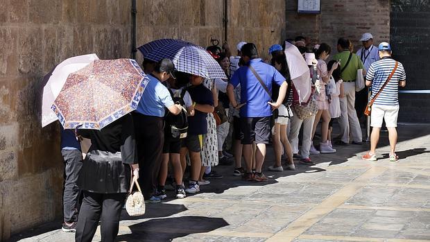 Turistas se refugian del calor a la sombra de la Giralda