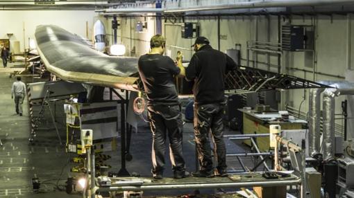 Dos operarios trabajando en las alas del avión