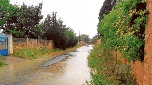 Muchas calles de la urbanización no tienen aceras y se anegan cada vez que llueve