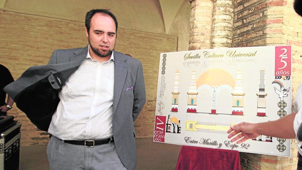 Hugo Montalbán junto al cartel de su diseño de la portada de la Feria de 2017