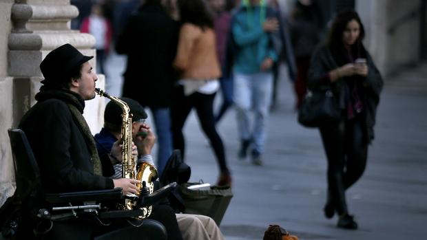 Un hombre toca en la plaza Nueva