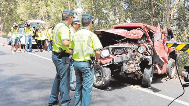 Agentes de la Guardia Civil junto a un coche accidentado