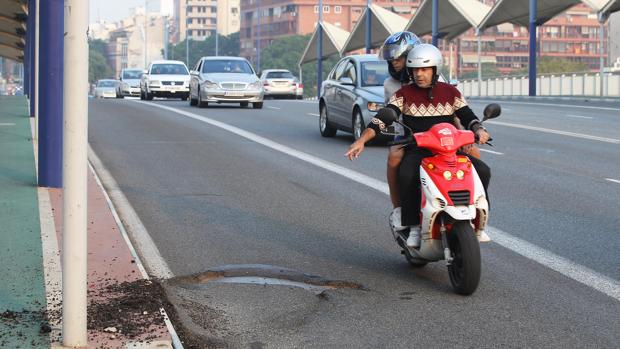 Un motorista señala el bache en una imagen de 2015