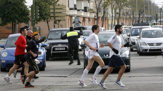 Un policía local cortando el tráfico por el maratón de Sevilla