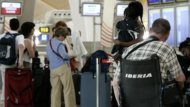 Un pasajero aguarda en una silla de ruedas a que salga su vuelo