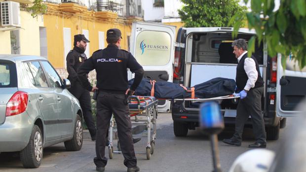 La Policía Nacional, escoltando el cadáver de la mujer mientras es retirado por los servicios funerarios