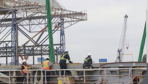 Varios trabajadores, durante la carga de una megaestructura