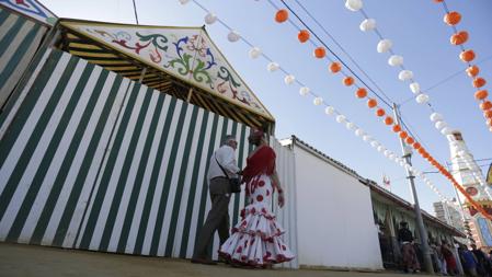 Una pareja pasea por el real con algunas casetas ya cerradas