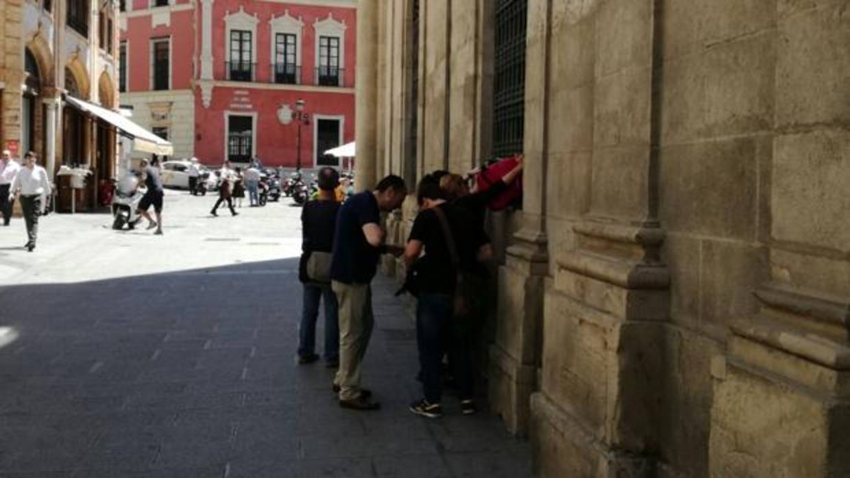 Varias personas introducen sacos de dormir por la ventana de Participa Sevilla en el Ayuntamiento