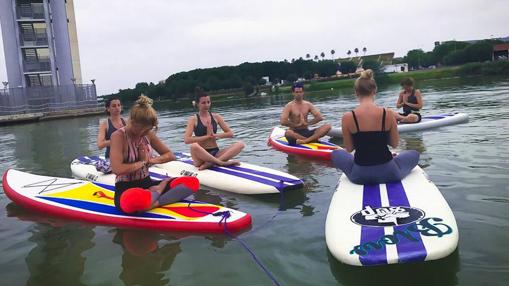 Clases de SUP yoga junto a la Torre Schindler de la Isla de la Cartuja