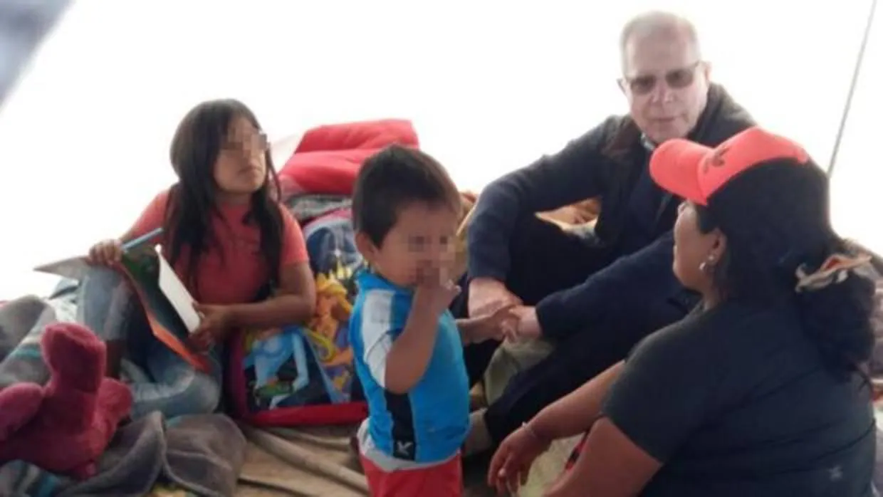 El delegado episcopal de Misiones, Eduardo Martín Clemens, con una familia afectada por inundaciones en Perú