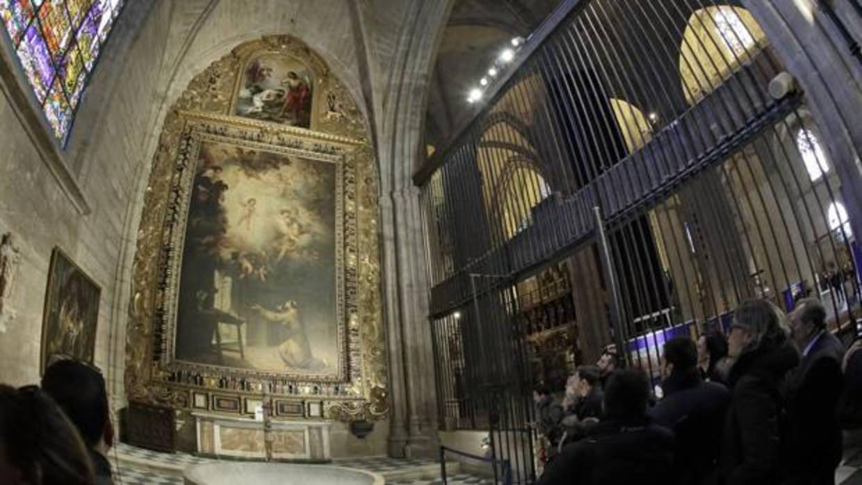 Algunos visitantes observan el cuadro «La visión de San Antonio de Padua» en la Capilla Bautismal de la Catedral