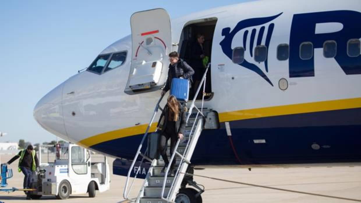 Dos pasajeros bajan de un avión en el aeropuerto de Sevilla