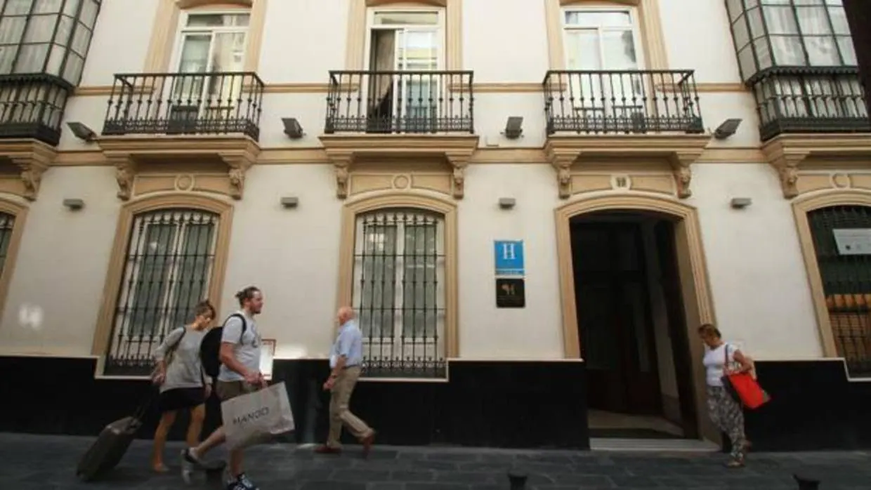 Varios visitantes en la entrada de un céntrico hotel de Sevilla