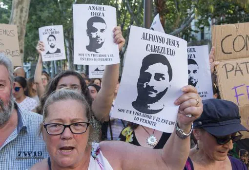 Manifestantes portan carteles con el rostro de los cinco condenados