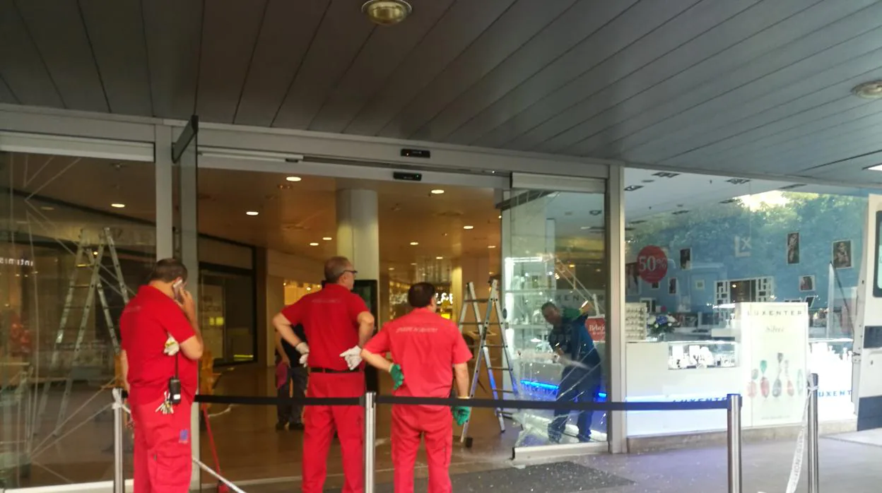 El personal de mantenimiento del Nervión Plaza reparando la puerta destrozada por los aluniceros