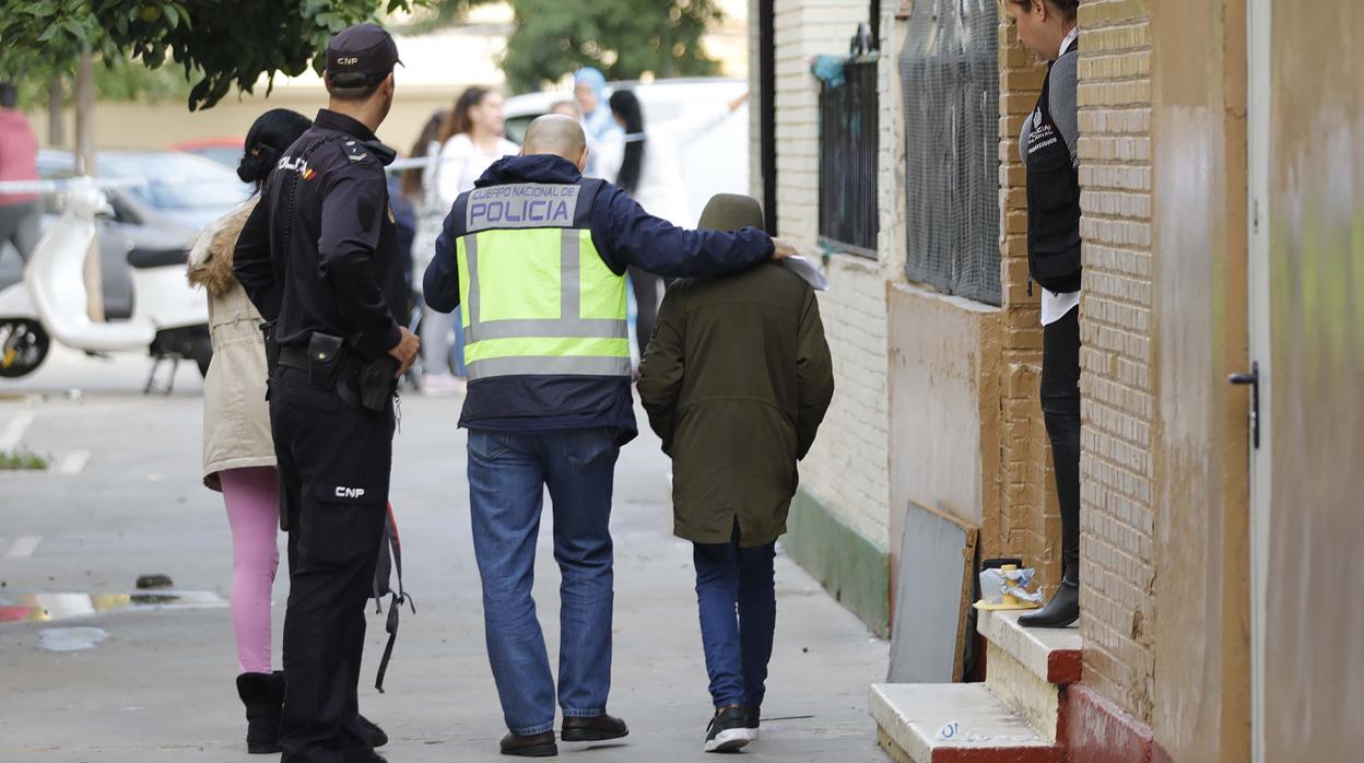 Un agente acompaña al hijo de Fátima, que sale de la casa tras producirse el crimen