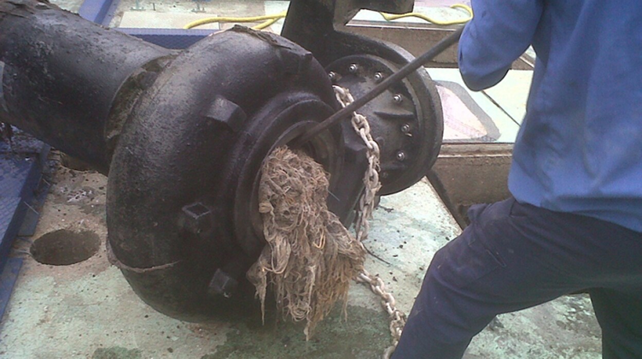 Un empleado de Emasesa ertira restos sólidos y toallitas húmedas de la red de saneamiento de Sevilla