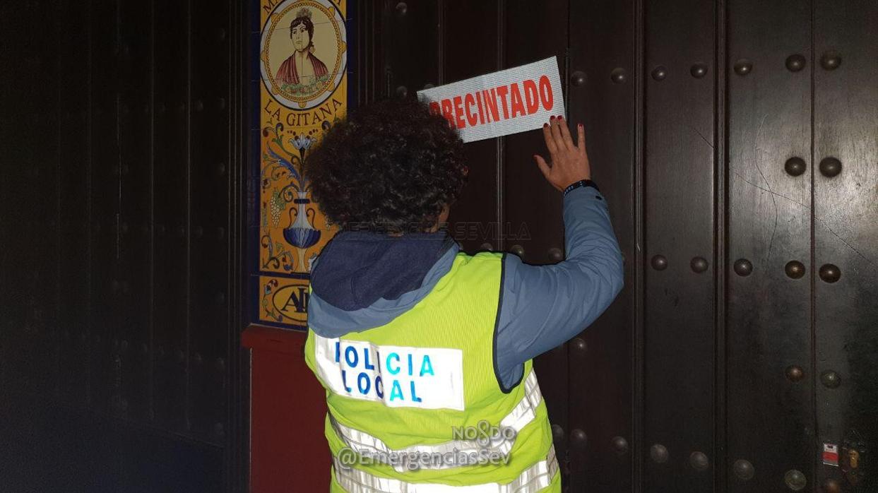 Una agente de la Policía Local de Sevilla precinta uno de los establecimientos
