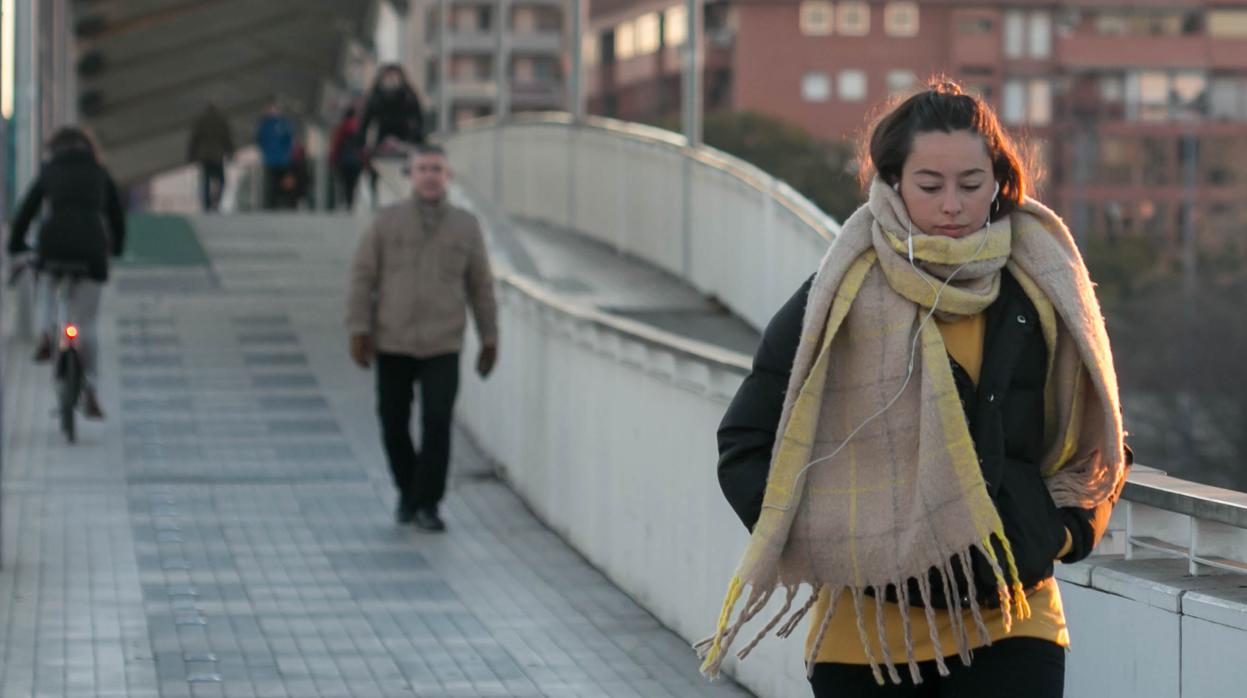 Una joven camina por Sevilla bien abrigada