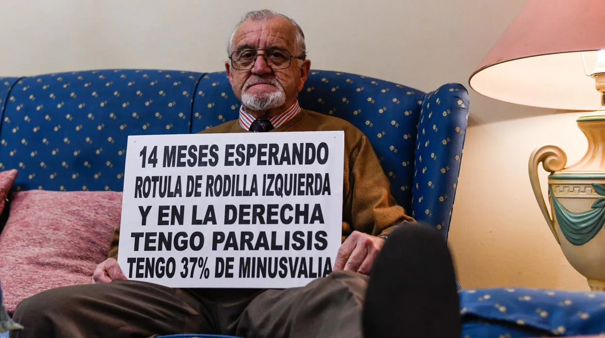 Ricardo Bernal en su casa con un cartel en el que detalla su situación