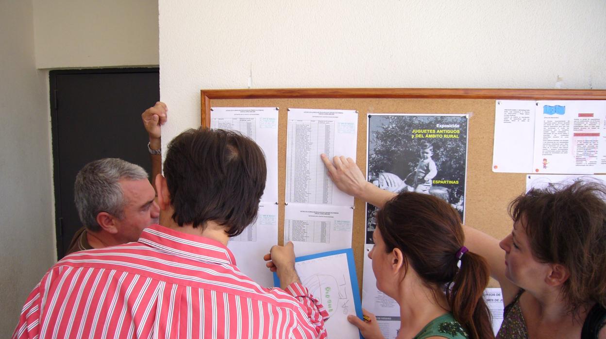 Unos padres consultan las listas en un colegio