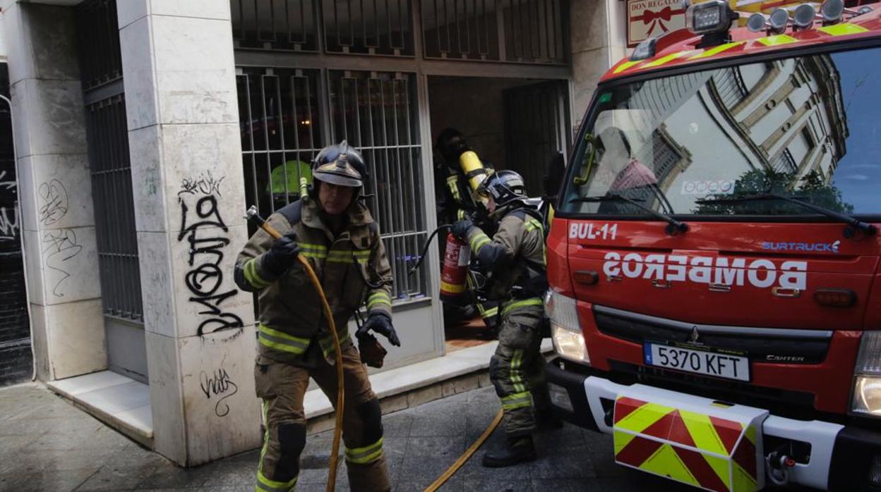 Bomberos actuando en la calle San Eloy de la capital hispalense