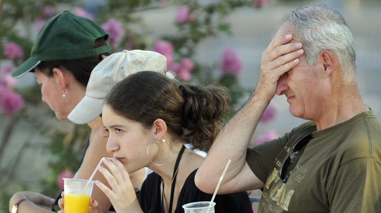 Turistas en la Plaza de España refrescándose con una bebida fría