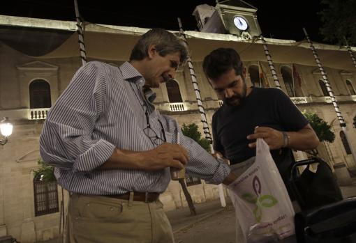 José Rivera, un carpintero en paro de 61 años, coge una bolsa con comida que le ofrece «Chemi»