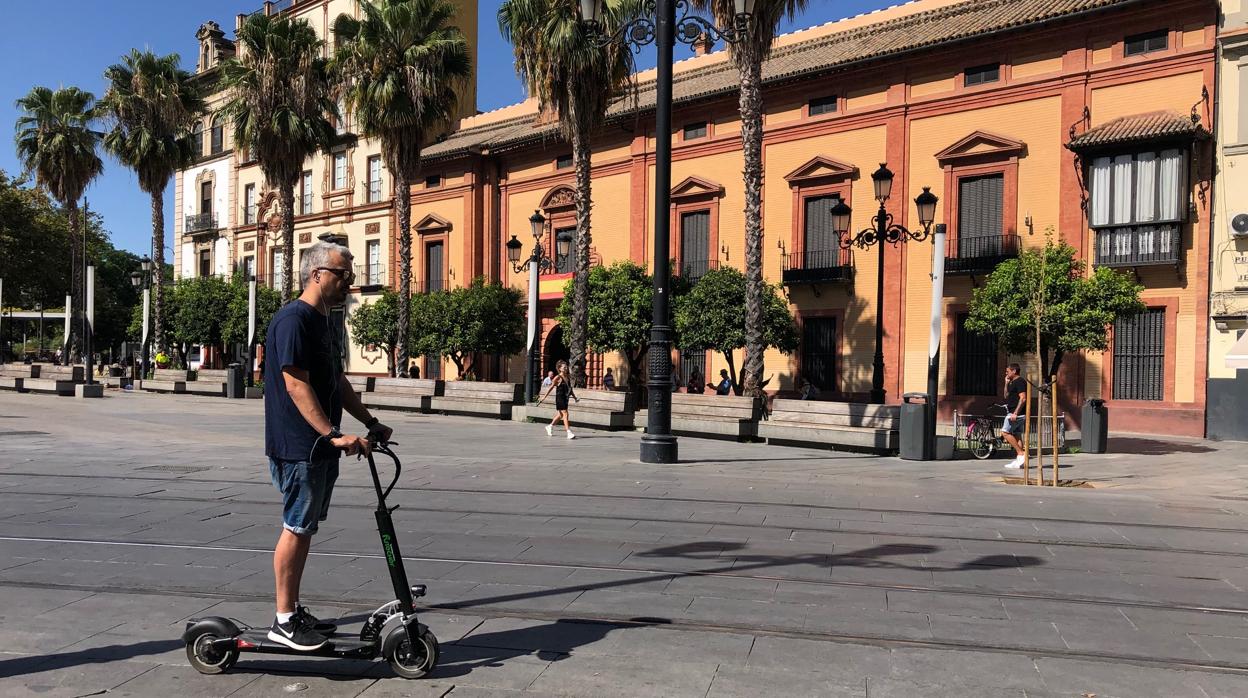 Un joven circula con un patinete por Sevilla