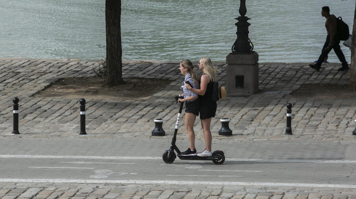 Dos jóvenes montan en un patinete