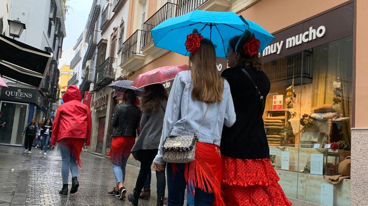 Un joven se resguarda de la lluvia con un paraguas en Sevilla