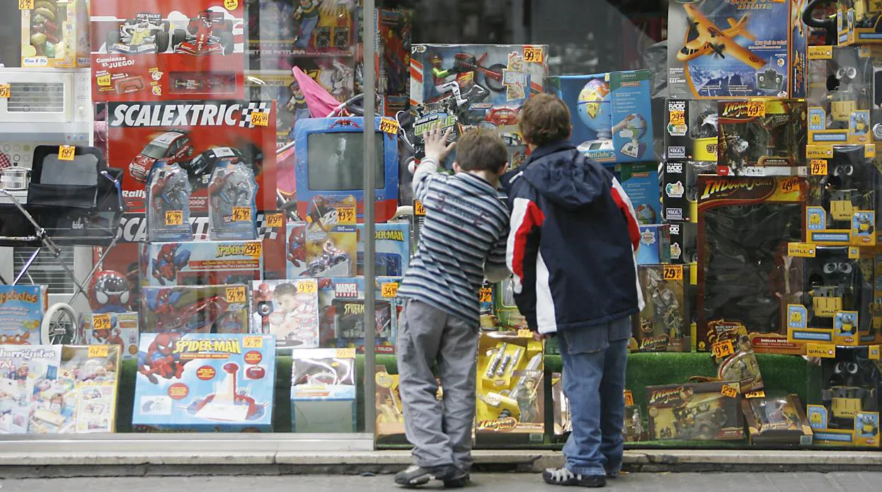 Niños asomados a una tienda de juguetes