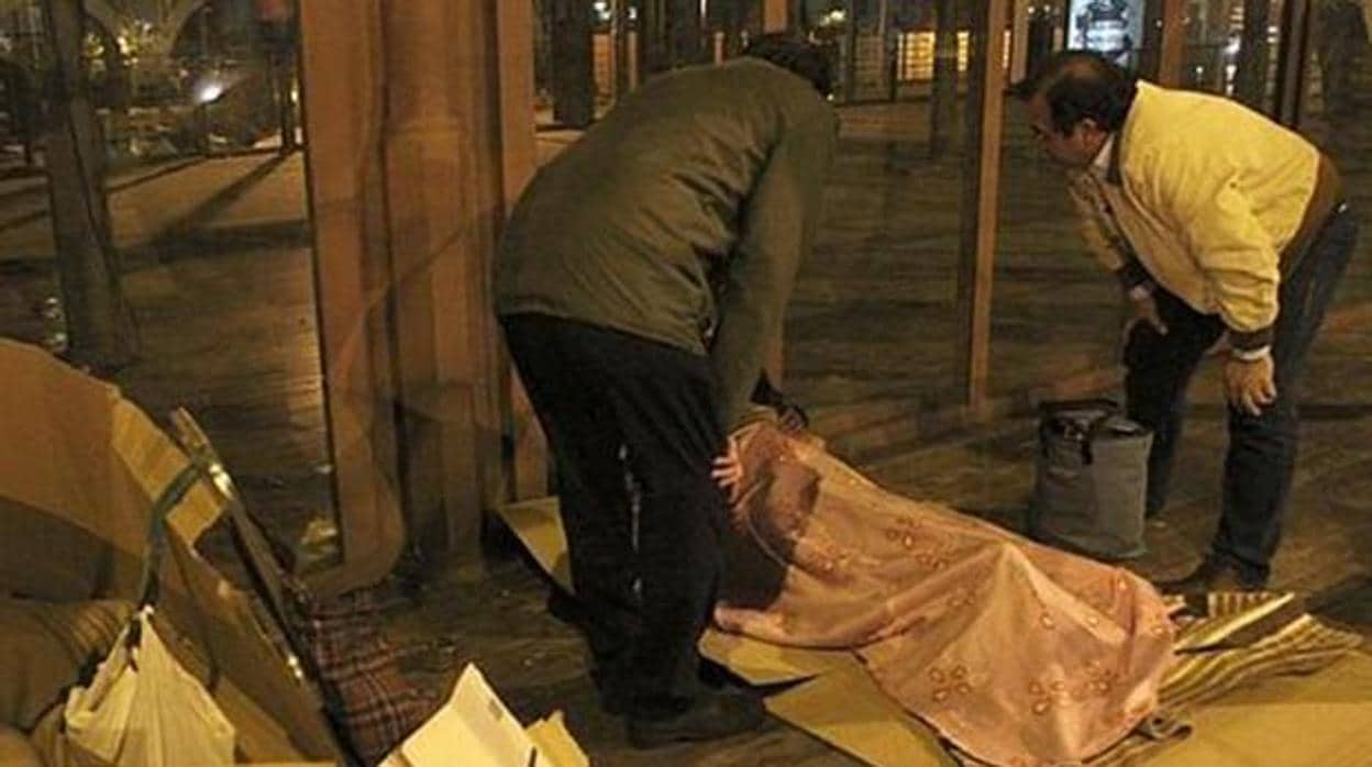 Dos voluntarios atienden a una persona en una calle de Sevilla