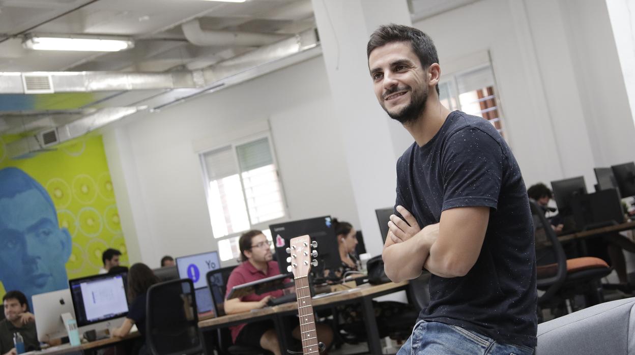 Héctor Giner posa junto a una guitarra, otra de sus pasiones, en la oficina de Z1 de Sevilla