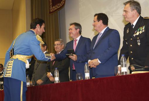 El alcalde entrega una de las condecoraciones a un agente de la Policía Local