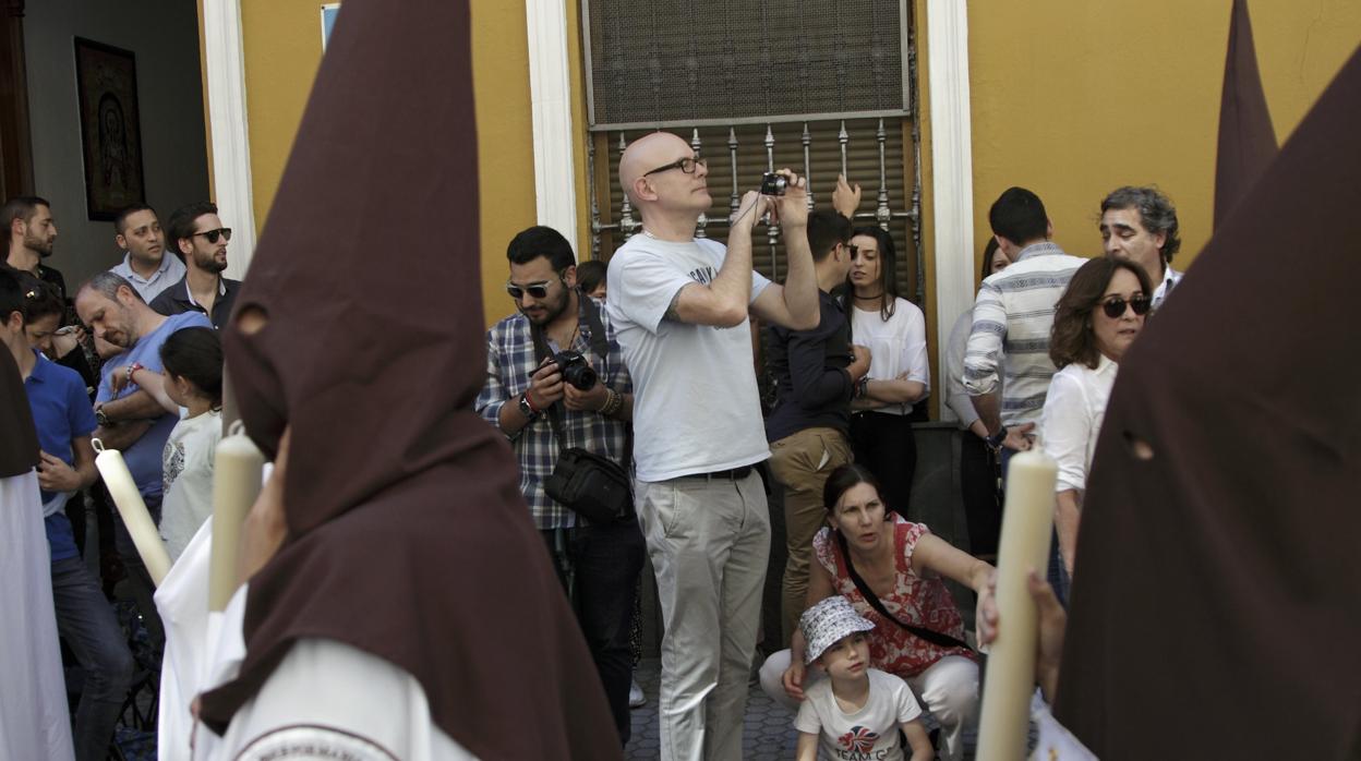 Turistas durante una procesión de Semana Santa en Sevilla