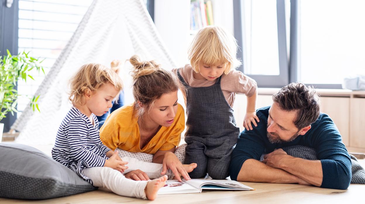 Familia leyendo un libro en casa